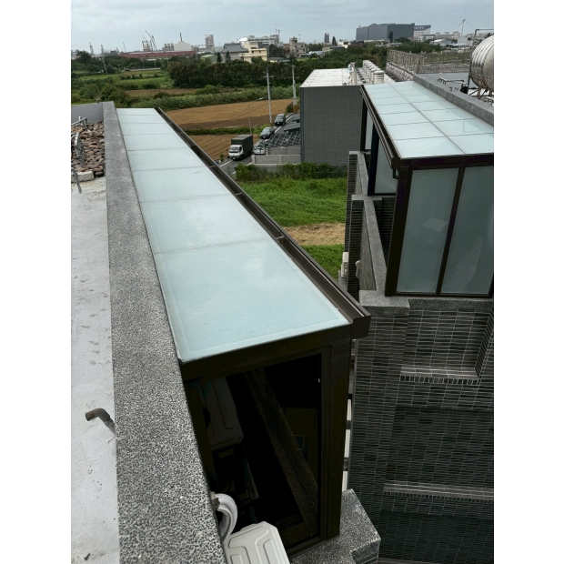 屋頂側邊不鏽鋼烤漆採光罩施工實景，採用霧面玻璃面板與金屬骨架延伸設計