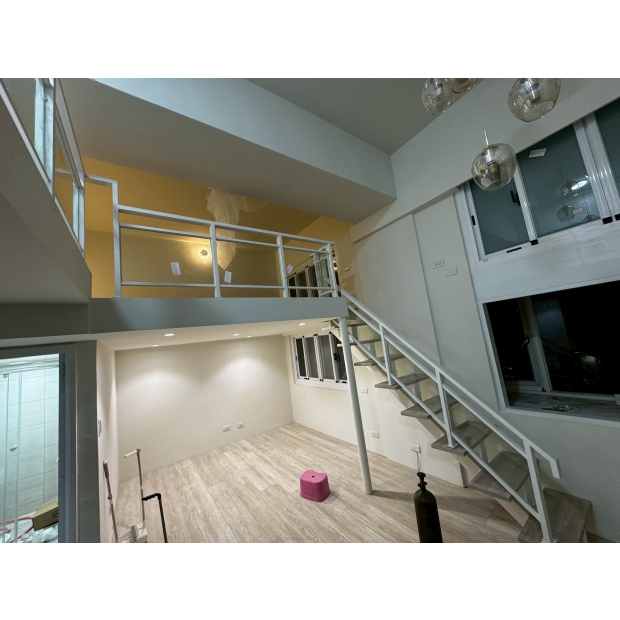 室內夾層樓梯安裝之烤漆玻璃欄杆扶手完成實景，搭配白色金屬框架與透明玻璃面板。