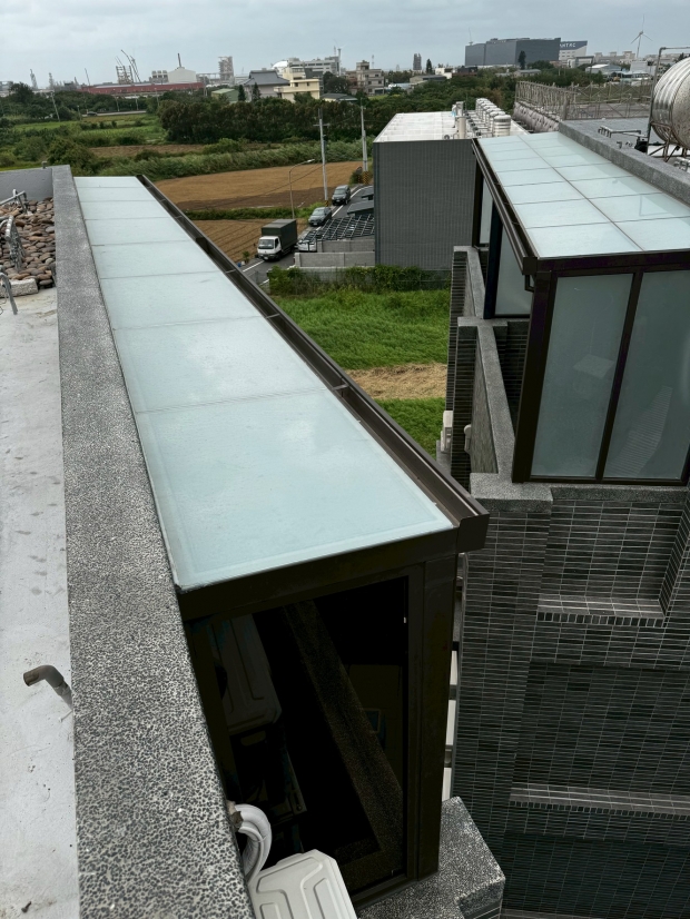 屋頂側邊不鏽鋼烤漆採光罩施工實景，採用霧面玻璃面板與金屬骨架延伸設計